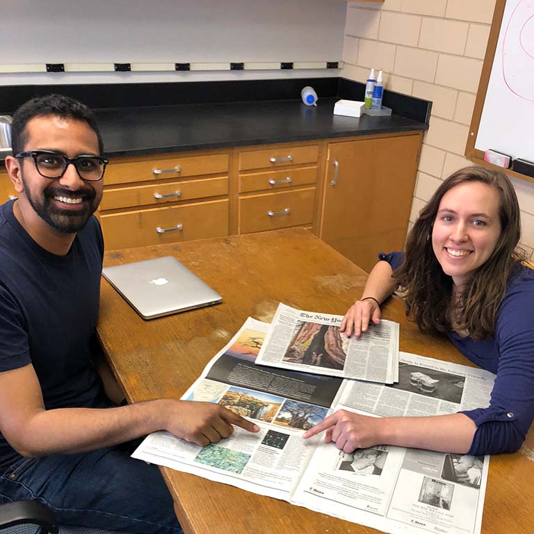 Ankur Dalia, assistant professor of biology, and Courtney Ellison, Ph.D. student in the Brun lab, point to the article about their research printed in The New York Times on June 19, 2018.